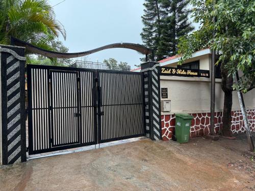 a black gate in front of a building at Zaid & Nida House in Panchgani