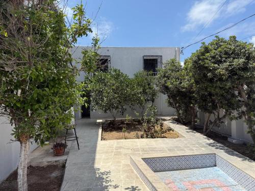 a courtyard with trees in front of a building at Évasion côtière à la Corniche - Villa sur la mer in Banzart