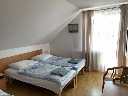 a bedroom with a bed and a window at Pensjonat Anna in Osłonino