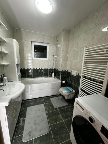 a bathroom with a tub and a toilet and a sink at Beauty Room Apartman in Prnjavor
