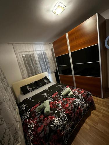 a bedroom with a bed with a black comforter at Beauty Room Apartman in Prnjavor