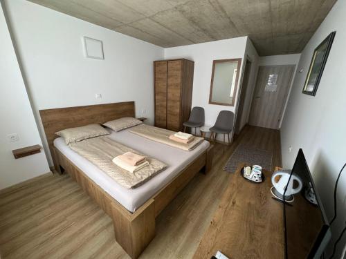 a bedroom with a bed and two chairs in it at Sobe, Rooms B&B - Vina Kauran in Zgornji Jakobski Dol