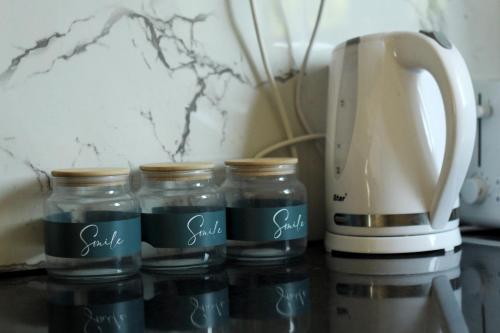 a group of glass jars next to a coffee maker at STAY Lemon Marie Apartment in Ktima