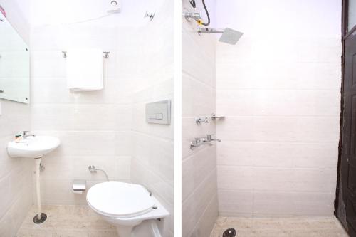 a white bathroom with a toilet and a sink at Hotel O Sky in Zirakpur