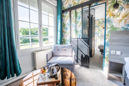a living room with a chair and a table at Sure Hotel by Best Western Port Jérome - Le Havre in Notre-Dame-de-Gravenchon