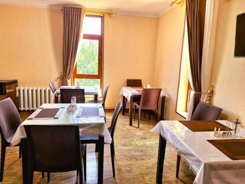 Un comedor con mesas y sillas y una ventana. en Mir Boutique hotel, en Bukhara