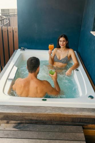a man and a woman sitting in a bath tub at Jungle Guardian - Rooftop Pool & Beach Club in Zona Hotelera Tulum in Tulum