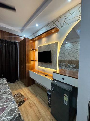 a bedroom with a desk with a tv and a bed at Heavenly stays in Greater Noida