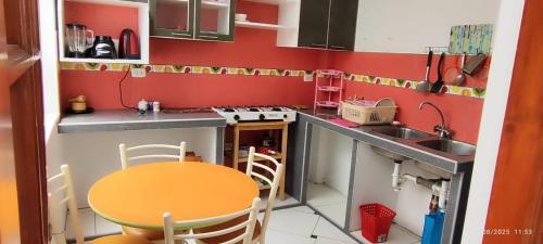 eine kleine Küche mit Tisch und Spüle in der Unterkunft Departamento El Mirador Concax in Los Baños del Inca