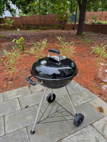 a bbq grill sitting on top of a patio at Grove Stay in Chakkarakkal