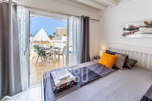a bedroom with a bed and a balcony with a table at Apartment Paraiso Royal in Arona