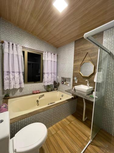 Un baño con bañera, inodoro y lavabo. en Cabana Mesa do Rei Com Vista Para o Litoral, en Marechal Floriano