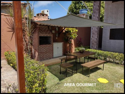 patio ze stołem piknikowym i parasolem w obiekcie Casa para até 12 pessoas em Tamandaré w mieście Tamandaré