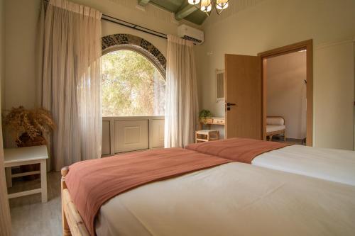 En eller flere senge i et værelse på Το Ρόδι Voutas Cottage house