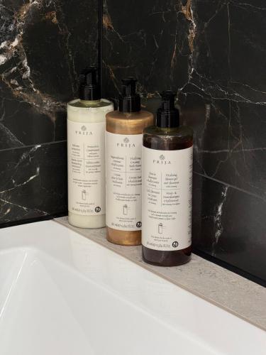 a trio of three bottles sitting on a shelf at CASHMERE Apartment - Airport Katowice-Pyrzowice in Siewierz