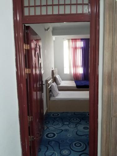 a room with a bedroom with a bed and a window at Hotel Kakh in Herāt