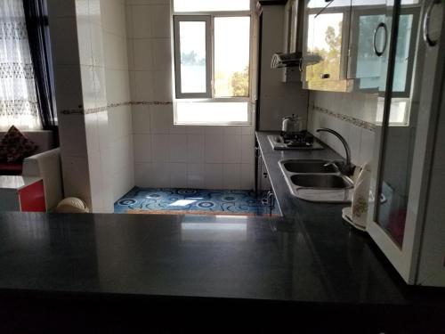 a small kitchen with a sink and a counter top at Hotel Kakh in Herāt