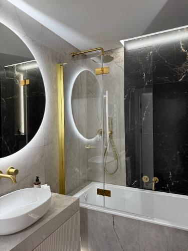 a bathroom with a sink and a glass shower at CASHMERE Apartment - Airport Katowice-Pyrzowice in Siewierz