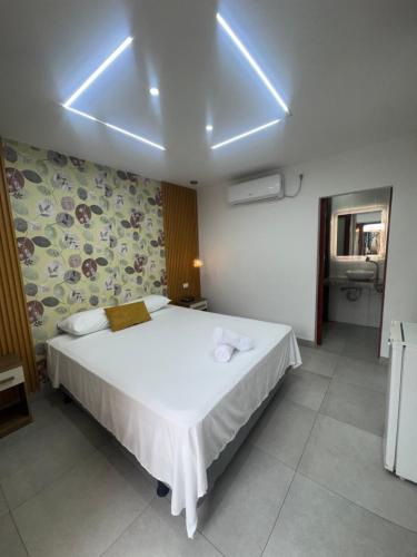 a bedroom with a white bed with lights on the ceiling at Hotel MELAO in Pedernales