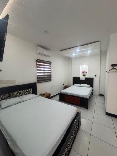 a hotel room with two beds and a window at Hotel MELAO in Pedernales
