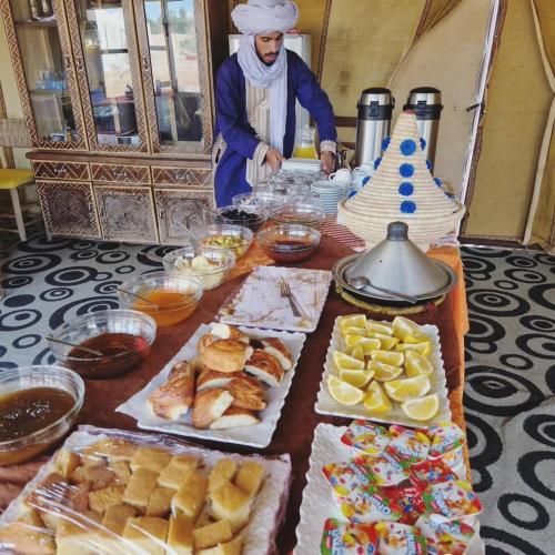 a man standing in front of a table with food at Cafe Restaurant Moove Oil in Rissani