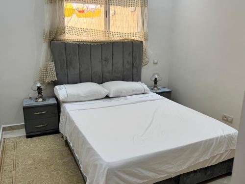 a bedroom with a large bed and two night stands at Résidence kettani in Zemmour Touirza