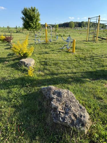 a park with a playground with rocks in the grass at CASHMERE Apartment - Airport Katowice-Pyrzowice in Siewierz
