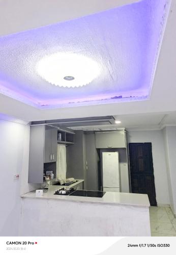 a kitchen with a ceiling with a purple at Raneziah Guesthouse in Kasane