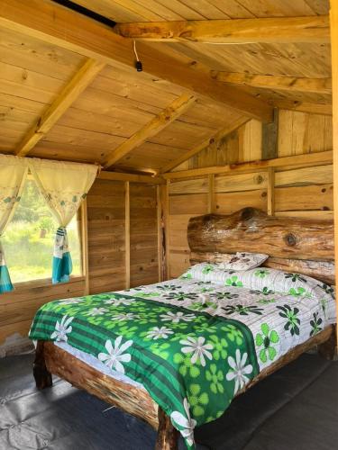 a bedroom with a bed in a wooden cabin at Cabaña El Descanso del Carpintero in La Marquesa