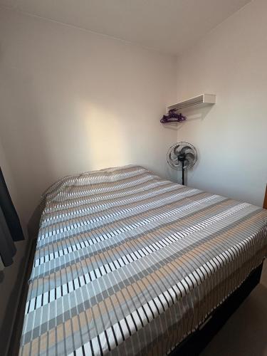 een slaapkamer met een bed in een kamer met een ventilator bij Apartamento mobiliado com piscina in Ananindeua