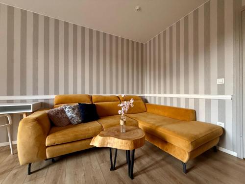 a living room with a brown couch and a table at Wrzosowy Zakątek 3 in Tuczno