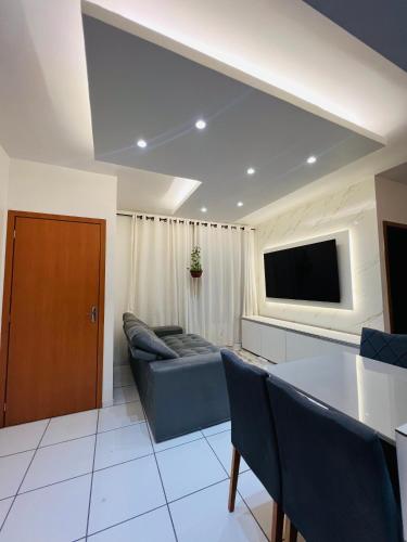 Una sala de estar con un sofá y un televisor de pantalla plana. en Apartamento completo - COP30, en Ananindeua