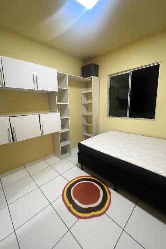 1 dormitorio con cama, ventana y alfombra en Apartamento completo - COP30, en Ananindeua