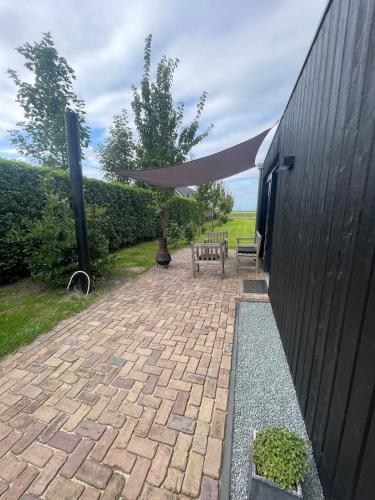 a patio with a picnic table and a canopy at Tiny house Steygheren in Stegeren