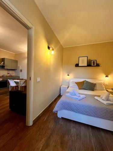 a bedroom with a white bed and a kitchen at La Casetta in Ladispoli