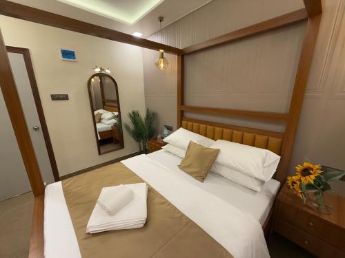 a bedroom with a large bed with white sheets and pillows at Zaid & Nida House in Panchgani