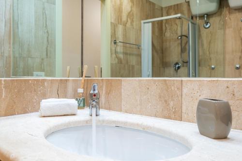 a bathroom counter with a sink and a mirror at Appartamento Cagliari centro con vista sul porto in Cagliari