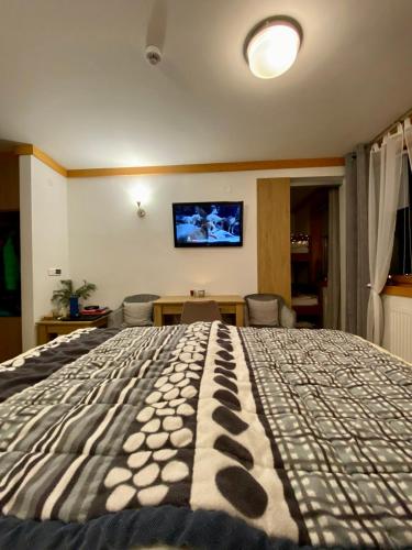 a bedroom with a large bed with a tv on the wall at Apartment U150 - Aparthotel Vučko - Private Host in Jahorina