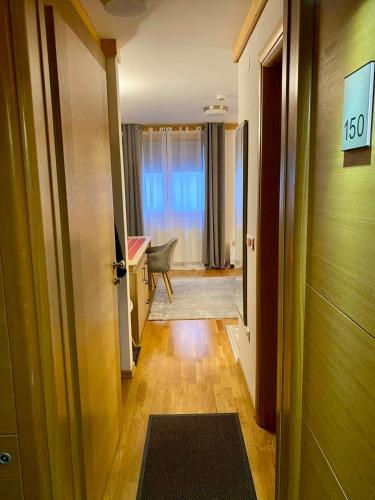 a hallway with a door to a room with a table at Apartment U150 - Aparthotel Vučko - Private Host in Jahorina