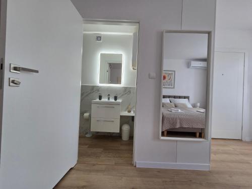 a bedroom with a mirror and a bed and a sink at Apartament Przedzamcze Malbork in Malbork