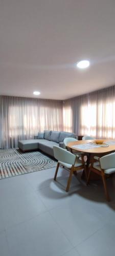 a living room with a couch and a table at Mirante da barra in Tramandaí