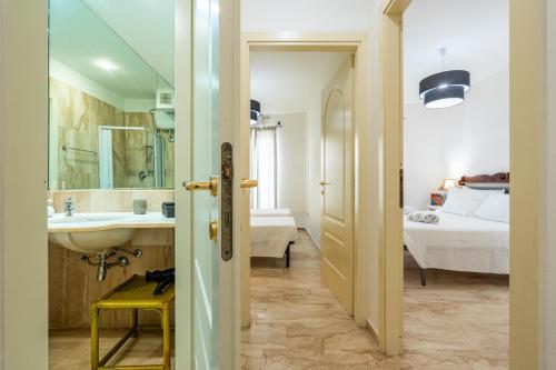 a bathroom with a sink and a bedroom with a bed at Appartamento Cagliari centro con vista sul porto in Cagliari