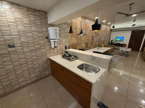 a kitchen with a sink and a living room at Zaid & Nida House in Panchgani
