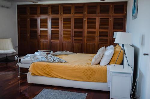 ein Schlafzimmer mit einem Bett mit einer Holzwand in der Unterkunft Ocean View Villa Retreat Quinta do Sol in Rabo de Peixe