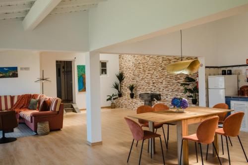 ein Esszimmer und ein Wohnzimmer mit Tisch und Stühlen in der Unterkunft Ocean View Villa Retreat Quinta do Sol in Rabo de Peixe