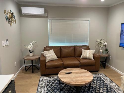 a living room with a brown couch and a table at Guest House in Torrance