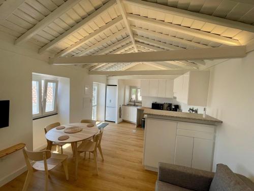 a living room with a table and a kitchen at Casa do Nitsa in Corvo