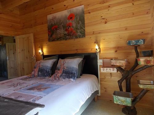 a bedroom with a bed in a log cabin at Les Gîtes De Morville in Malaumont