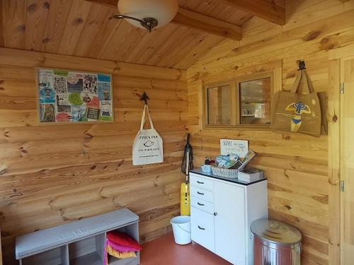 a cabin with wooden walls and a desk in a room at Les Gîtes De Morville in Malaumont