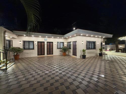 a large white building with a courtyard at night at Zaid & Nida House in Panchgani